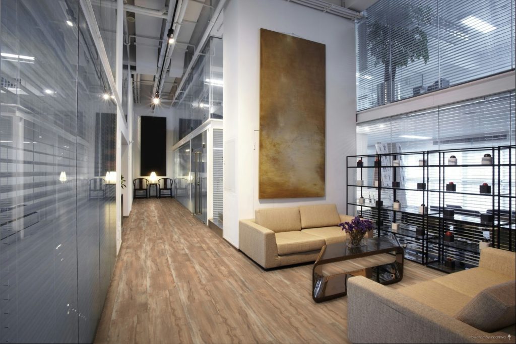 Espacio contemporáneo con piso tipo madera que conecta visualmente áreas interiores y exteriores, generando continuidad visual y sensación de amplitud en el hogar.