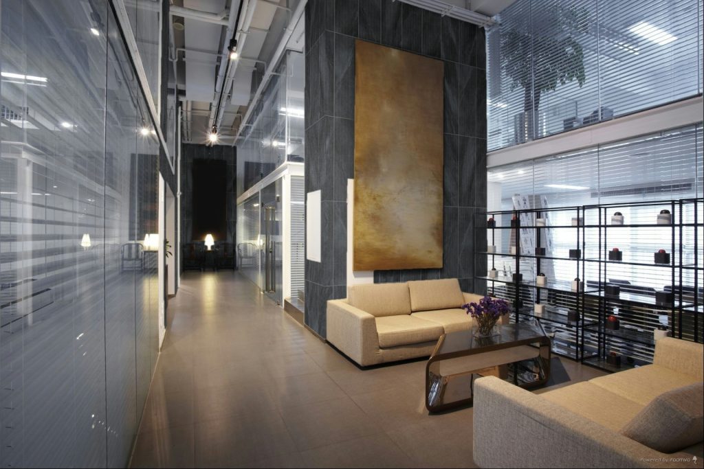 Revestimiento de muro oscuro en lobby moderno, tendencia en muros con presencia arquitectónica para 2026.